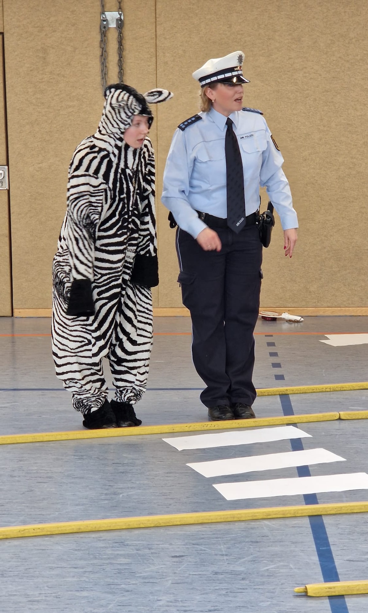 Die Polizistin hilft dem Zebra über die Straße.